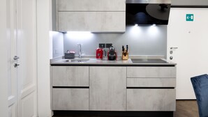 A modern kitchen with a built-in oven, a coffee maker, and a kettle on the counter.