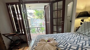 A bedroom with a bed, a window, and a door leading to a balcony. - Hotel Flor De Limao (Santa Cruz Cabralia)