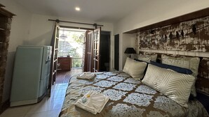 A bedroom with a bed, bedside table, and a view of the outside. - Hotel Flor De Limao (Santa Cruz Cabralia)
