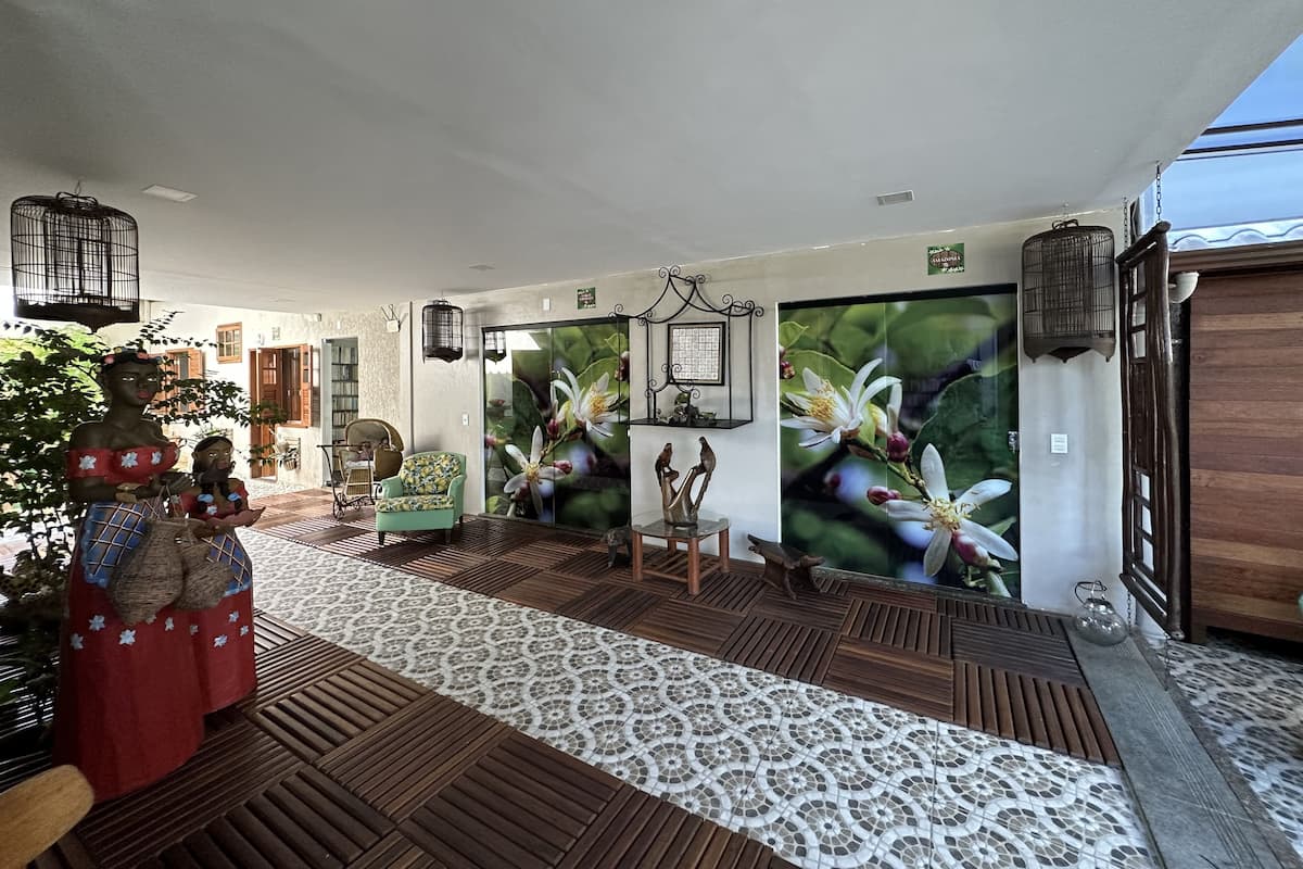 A room with a patterned floor, a large window, and a wall with a floral mural.