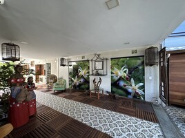 Una habitación con piso estampado, un ventanal grande y una pared con un mural floral.