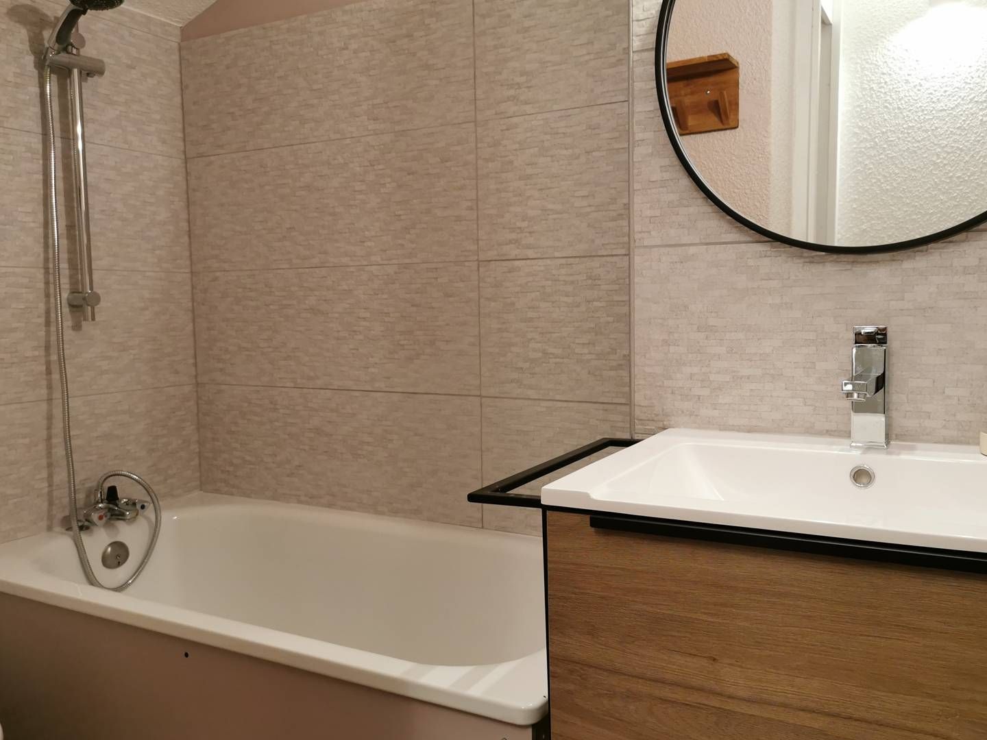 A bathroom with a bathtub, a shower, a sink, and a mirror.