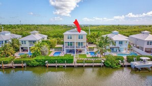 A waterfront property with multiple houses, a dock, and a swimming pool. - W04 - Spacious 4 bed, 3 bath home in Sombrero with private pool (Marathon)