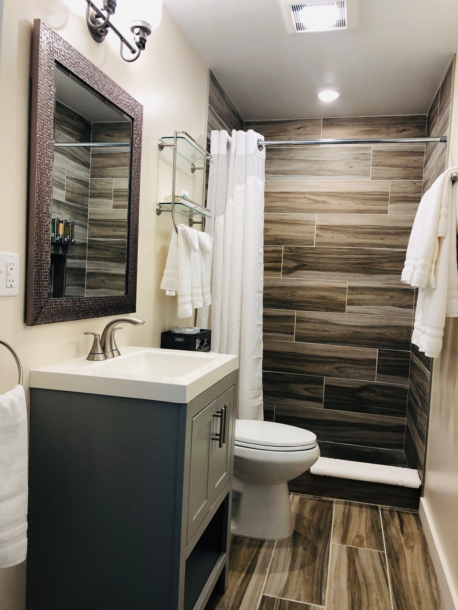 Une salle de bain moderne comprenant un meuble-lavabo, des toilettes et un espace douche.