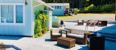 A modern outdoor seating area with wicker furniture and a poolside view.
