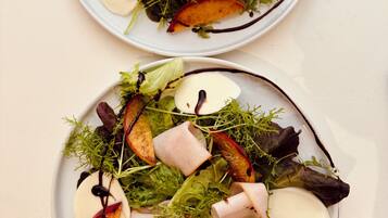 Deux assiettes de nourriture composées de différents légumes et de tranches de viande.