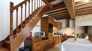 A kitchen with wooden cabinets, a microwave, and a dining table set for four.