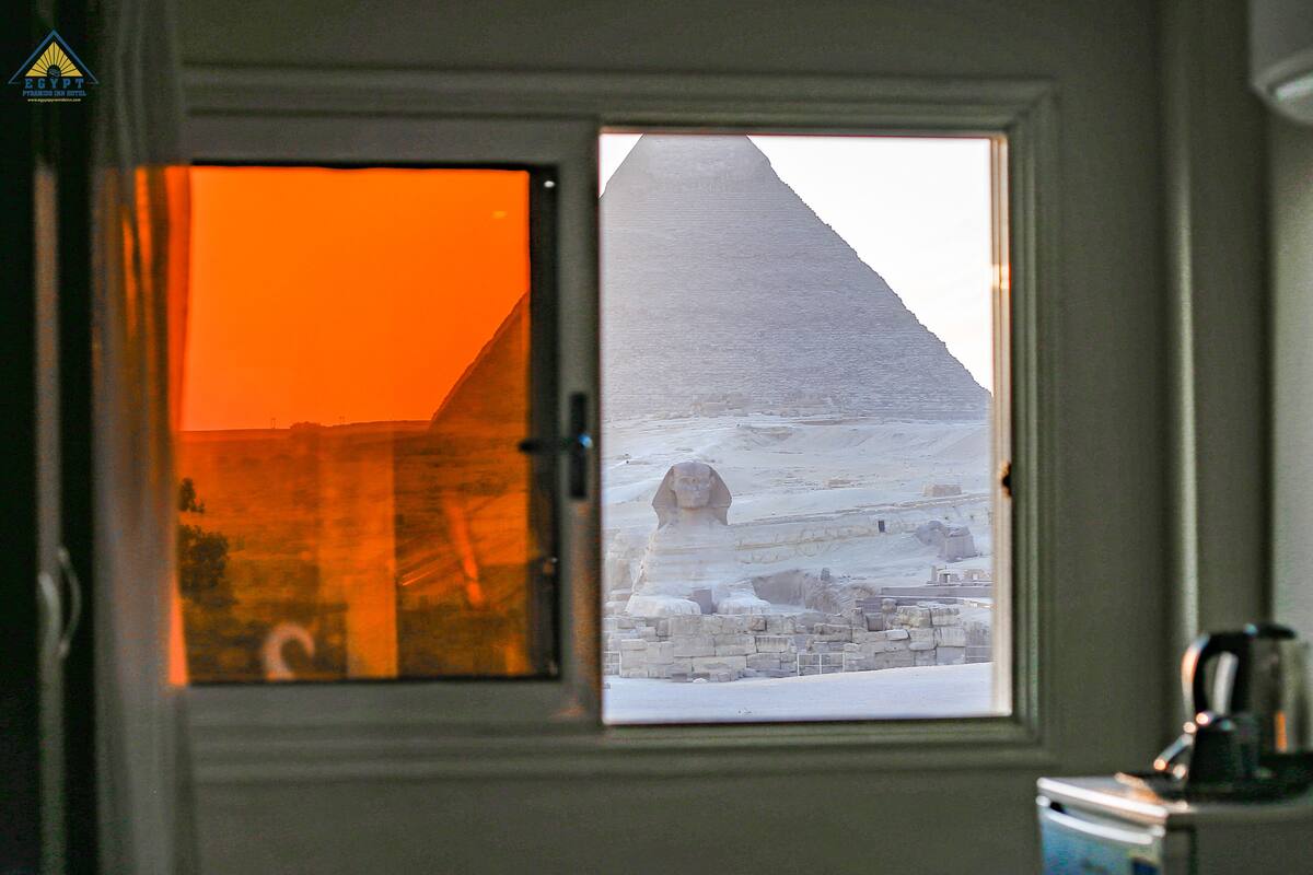 A window view of a pyramid and a desert landscape.