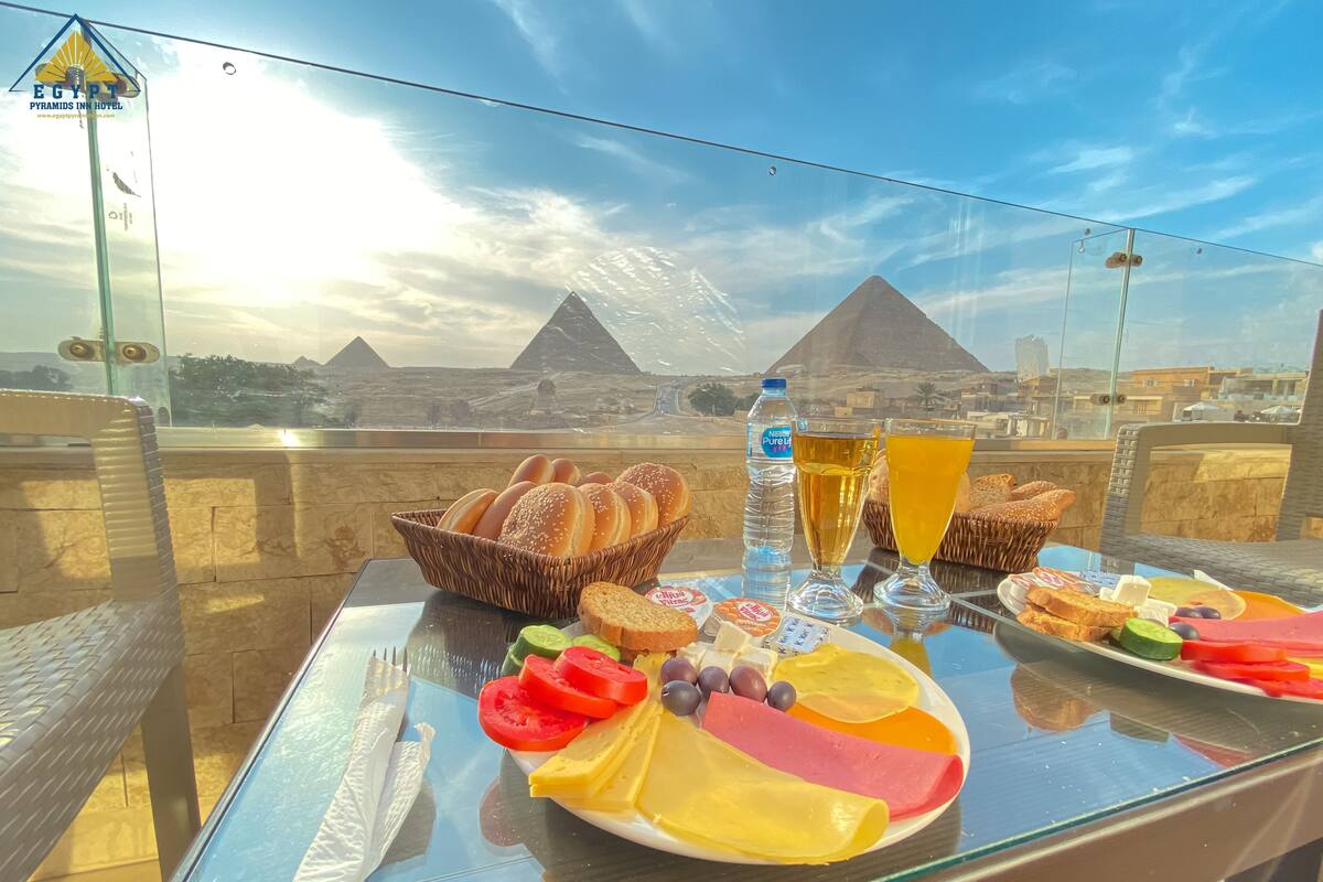 A table with breakfast items and a view of the pyramids.