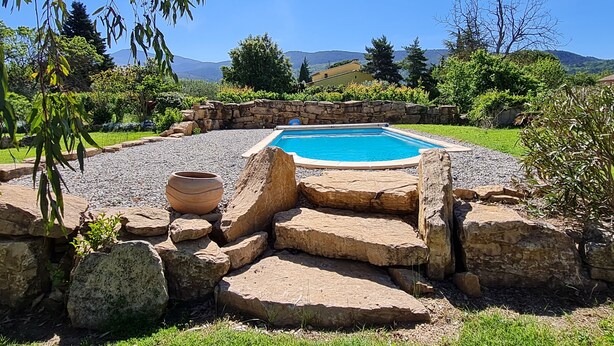 A rectangular swimming pool surrounded by a stone wall, with a grassy area and trees in the background. - Villa at the foot of Mont Ventoux for 7 people in Malaucène with private pool (Malaucène)