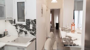 A modern kitchen with a marble backsplash, a built-in microwave, and a sink. - Philoxenia Flat (Athina)
