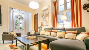A living room with a sofa, armchairs, a coffee table, and a chandelier. - Families, calm city center 3 bedrooms 5 bathrooms wifi air conditioning heating (Sevilla)