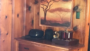 A wooden cabinet with a sign reading "THE LAKE IS MY HAPPY PLACE," a painting of a tree, and a small lamp. - Amazing view of Lake Norfork, room for everyone! (Mountain Home)
