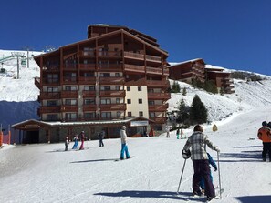 A multi-story hotel with balconies and ski slope access.