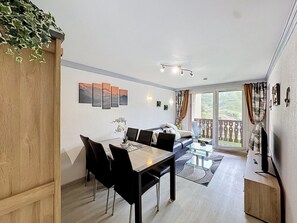 Un espacio habitable moderno con comedor, sofá y un balcón con vistas.