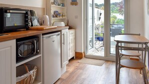 A kitchen with a microwave, toaster, and wooden countertop.