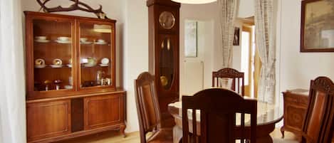 Un comedor con un aparador de madera, una mesa, sillas y una lámpara colgante.