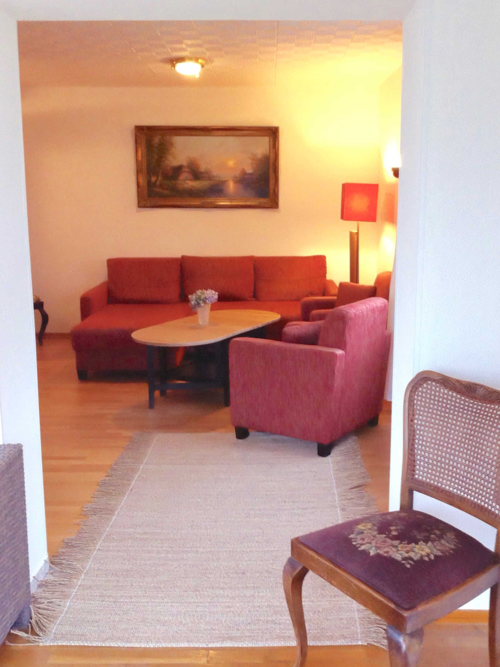 A living room with a sofa, armchairs, a coffee table, and a chair.