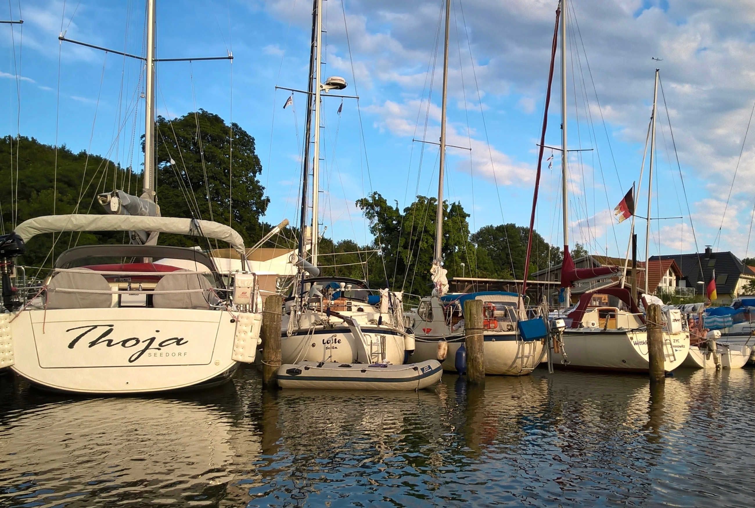 A marina with several boats docked, including one named 'Thoja'.