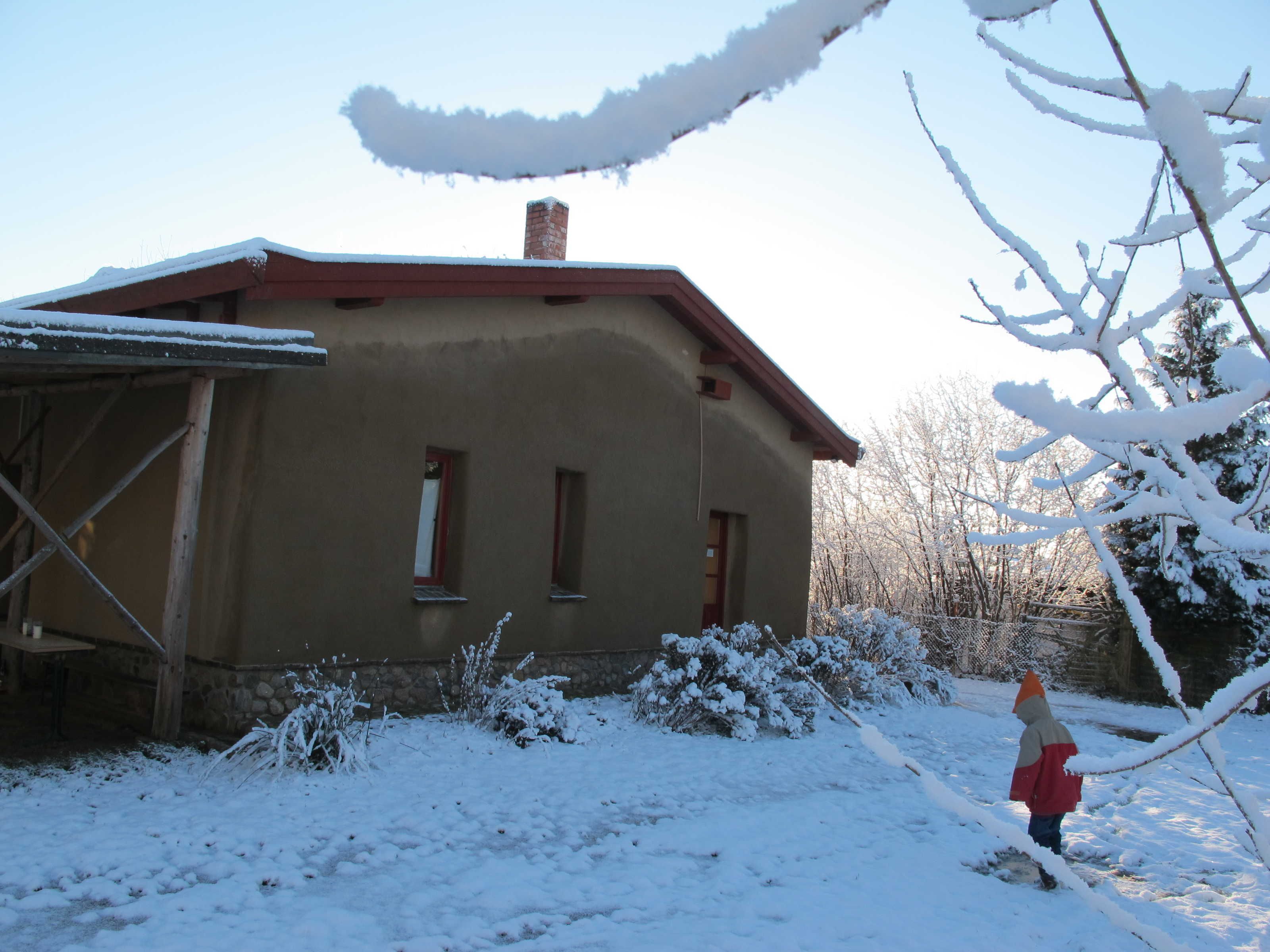 Une maison avec un toit en pente, deux fenêtres et une cheminée.