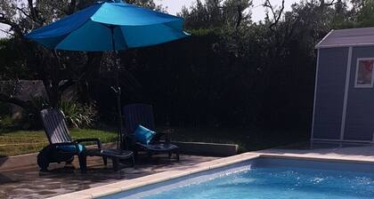Estudio en villa con jardín y piscina.