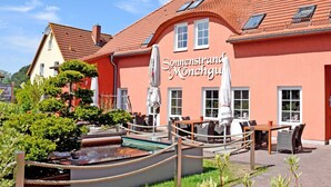 Un bâtiment à la façade rouge, sur lequel on peut lire l’inscription « Sonnenstrand Monchgut ».