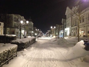 A snow-covered street at night with buildings on either side. - Vacation apartment 6 - Ferienwohnungen Hoffmann (Binz)