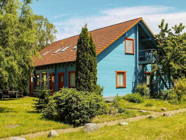 A two-story house with a red-tiled roof, blue exterior walls, and a small balcony. - Double room 4 - Rankwitzer Hof (Rankwitz)