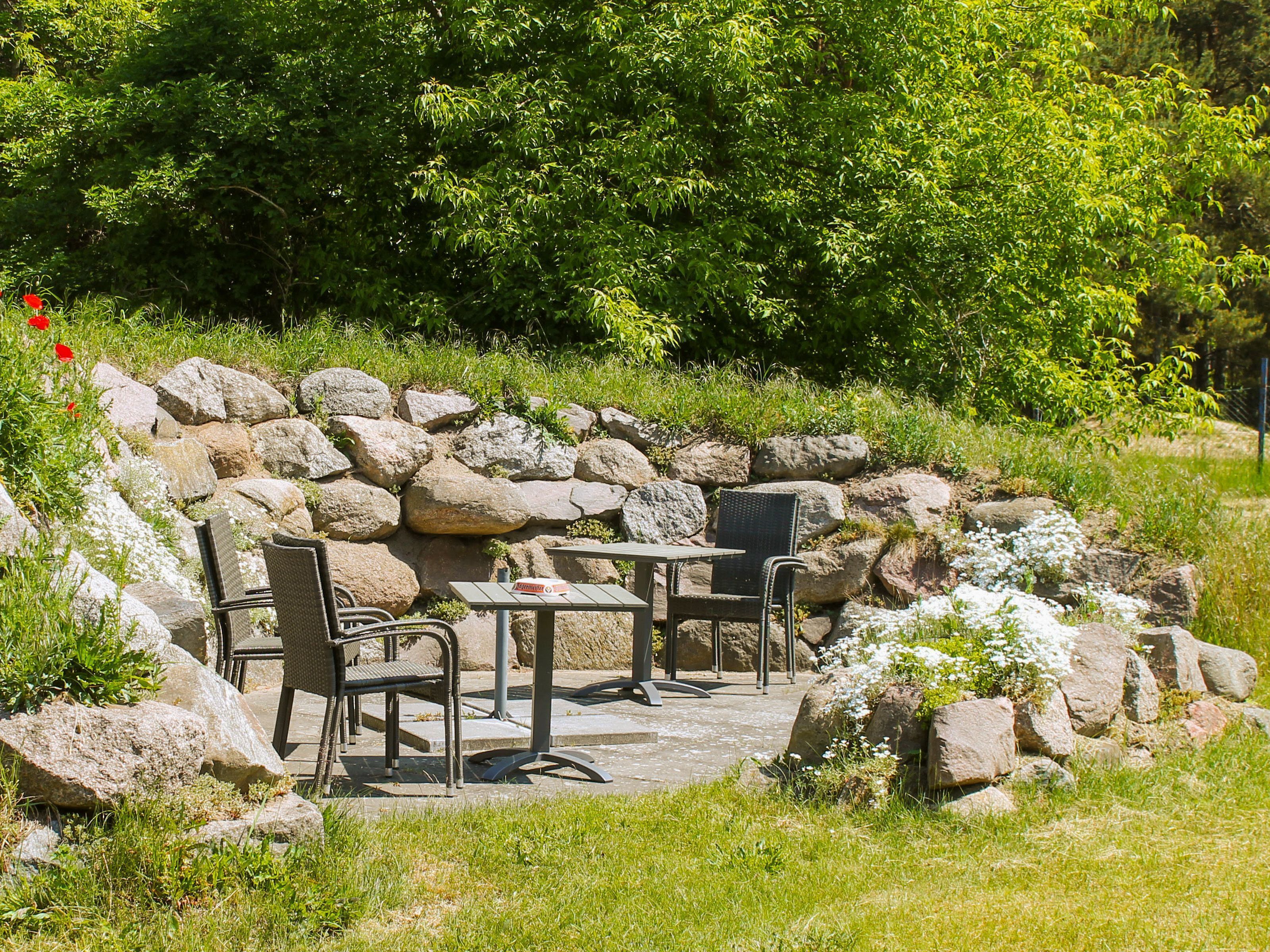 An outdoor seating area with stone walls and a table and chairs.