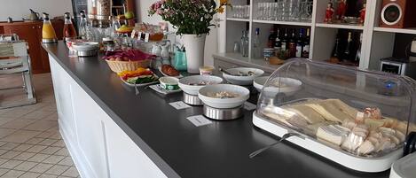 En buffet med forskellige retter, en blomstervase og et udstilling af glas.