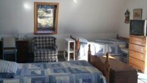 A bedroom with a bed, a chair, a dresser, and a television. - Pat's Place - Peacefull & charming cottage (Deer Isle)