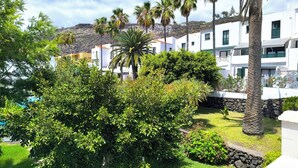 A resort with white buildings, palm trees, and a pool. - Amelia Cancajos: Comfort Swimming pool and beach nearby (Breña Baja)