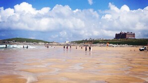 Una playa con un edificio grande al fondo.