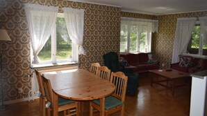 A dining area with a wooden table and chairs, a sofa, and a small table. - Magnificent house with big garden (Munkfors)