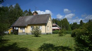 A two-story house with a sloped roof, a chimney, and a small porch. - Magnificent house with big garden (Munkfors)
