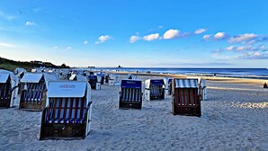 Cabañas de playa con vista al mar, dispuestas en filas sobre la arena.