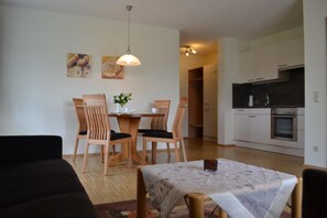 Un salon moderne comprenant un coin repas, une cuisine et un couloir.