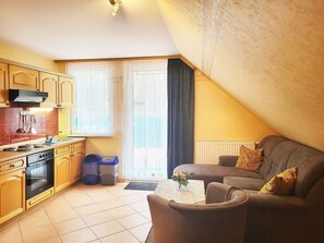 Kjøleskap, mikrobølgeovn og høy barnestol