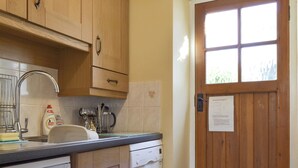A kitchen with wooden cabinets, a sink, and a Bosch dishwasher. - 1 bedroom accommodation in Keswick (Keswick)