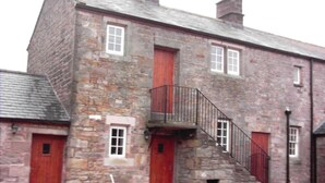 A stone building with red doors and windows, a staircase with a metal railing, and a date stamp of 2008. - Clougha View (Lancaster)