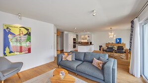 Un soggiorno moderno con un divano grigio, un tavolino in legno e un quadro appeso al muro.