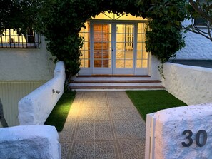 A building entrance with a tiled pathway leading to a door with glass panels. - Tourist residence Lilo 30 (Olías del Rey)