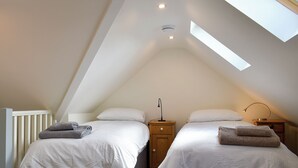 A bedroom with two beds, a skylight, and a ceiling fan. - 2 bedroom accommodation in Canon Frome, near Ledbury (Canon Frome, near Ledbury)