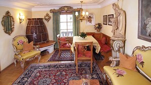 Una habitación con una mesa de centro de madera, un sofá, una silla y una pared decorativa con una estatua.