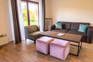 Una sala de estar moderna con un sofá, un sillón, un reposapiés y una mesa de centro.