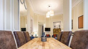 Ein Konferenzraum mit einem langen Holztisch, braunen Polsterstühlen, einer großen Vase und einer Kandelaber.