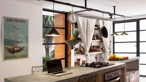 A modern kitchen with a central island, bar stools, a laptop, and a large window with curtains. - Colonial Oasis in Laureles I Patios&Jacuzzi (Medellin)