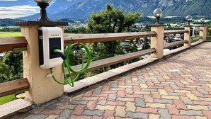 Un espacio al aire libre con vistas panorámicas a montañas, un sendero pavimentado y una estación de carga.
