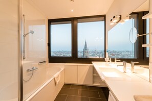 Bathtub, hair dryer, bathrobes, towels