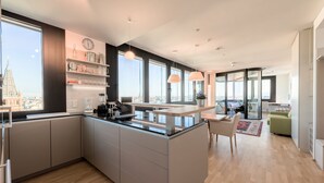 Una cucina moderna con isola centrale, ampie finestre e vista sulla città.